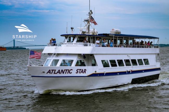 White tour boat 'Atlantic Star' on the water with passengers on deck, American flag at the rear.